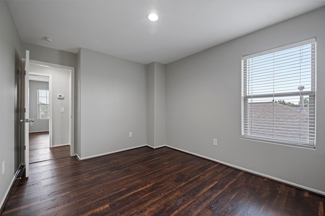 spare room with dark wood finished floors and baseboards