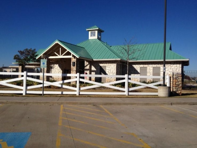 view of front of property with uncovered parking and fence