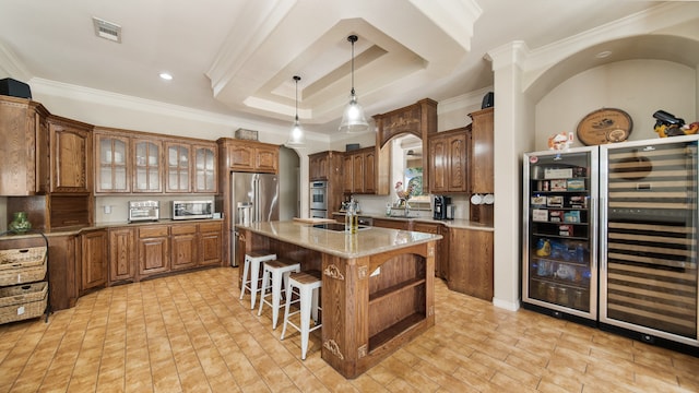 kitchen with light stone countertops, crown molding, an island with sink, and stainless steel appliances