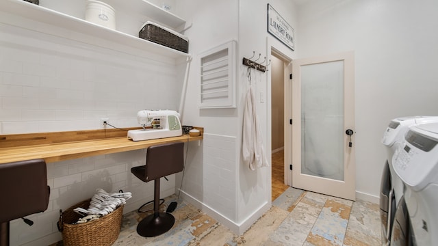 clothes washing area with independent washer and dryer and tile walls