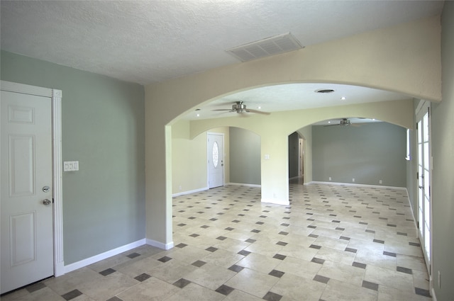 interior space with ceiling fan and a textured ceiling