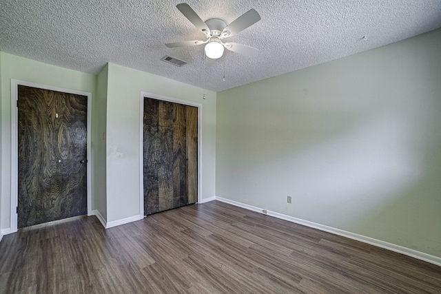 unfurnished bedroom with a closet, ceiling fan, a textured ceiling, and dark hardwood / wood-style floors