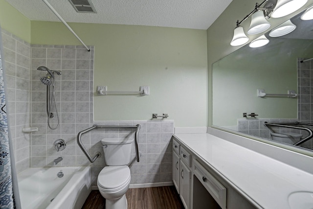 full bathroom with a textured ceiling, toilet, tile walls, vanity, and hardwood / wood-style flooring