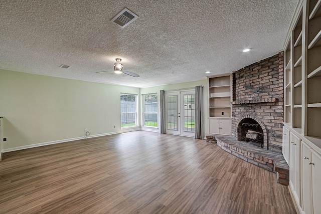 unfurnished living room with a textured ceiling, hardwood / wood-style flooring, and a fireplace