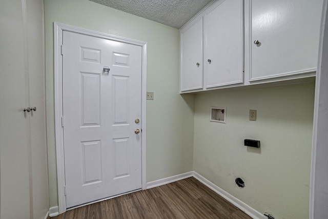 laundry area with hookup for a washing machine, a textured ceiling, dark hardwood / wood-style flooring, and cabinets