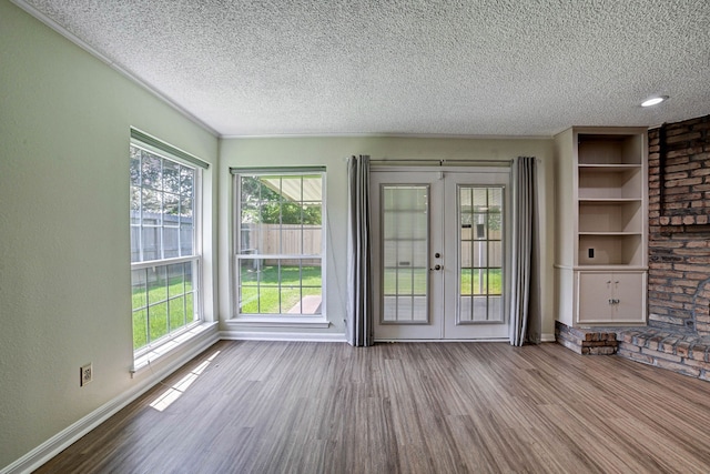 interior space with french doors, light hardwood / wood-style flooring, a textured ceiling, and a healthy amount of sunlight