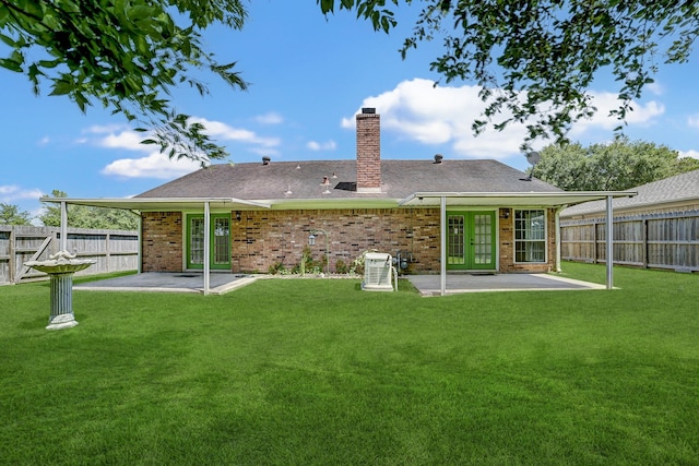 rear view of house with a yard and a patio area