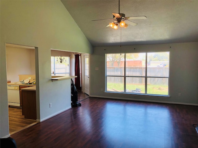 unfurnished living room featuring high vaulted ceiling, dark hardwood / wood-style floors, ceiling fan with notable chandelier, and a wealth of natural light