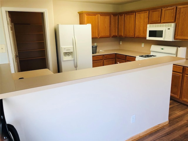 kitchen featuring dark hardwood / wood-style flooring and white appliances