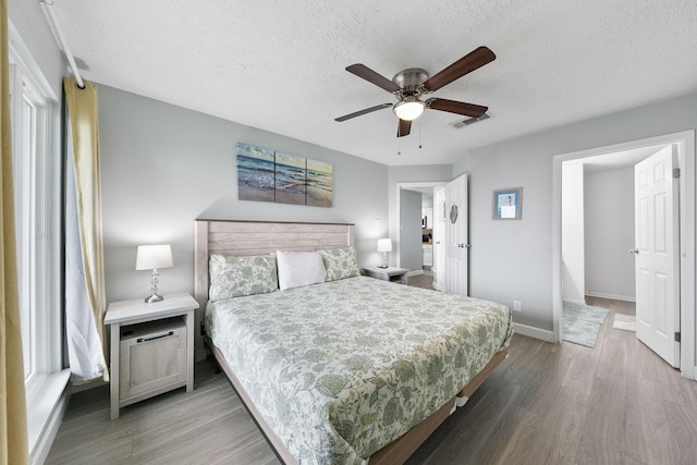 7600 Seawall Blvd Unit 115, Galveston, TX 77551 - bedroom featuring wood finished floors, a textured ceiling, baseboards, and ceiling fan