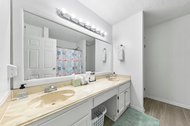 bathroom with vanity, wood-type flooring, a textured ceiling, and walk in shower