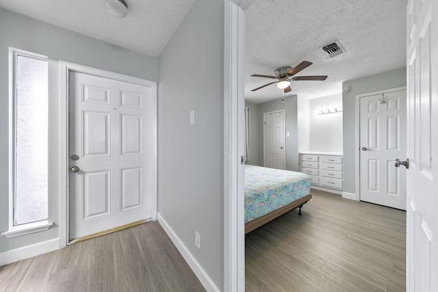 7600 Seawall Blvd Unit 115, Galveston, TX 77551 - bedroom featuring wood finished floors, baseboards, a textured ceiling, and ceiling fan