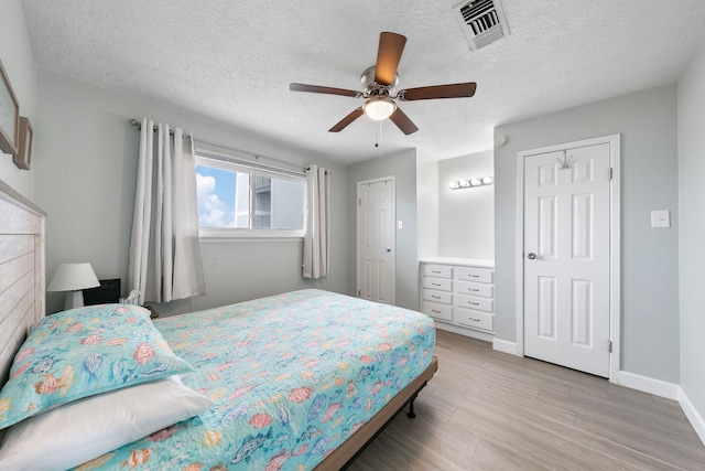 bedroom featuring ceiling fan, a textured ceiling, and light hardwood / wood-style flooring