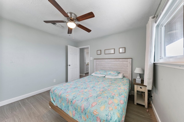 bedroom featuring ceiling fan, hardwood / wood-style flooring, and a textured ceiling