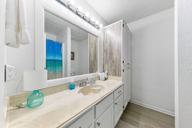 bathroom featuring vanity, hardwood / wood-style floors, and a textured ceiling