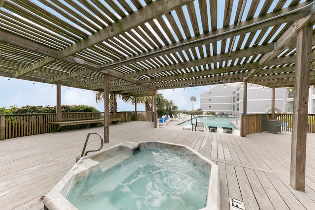 view of swimming pool featuring a jacuzzi, a deck, and a pergola