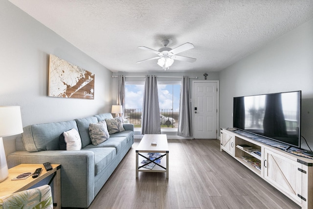 7600 Seawall Blvd Unit 115, Galveston, TX 77551 - living area featuring a ceiling fan, wood finished floors, and a textured ceiling