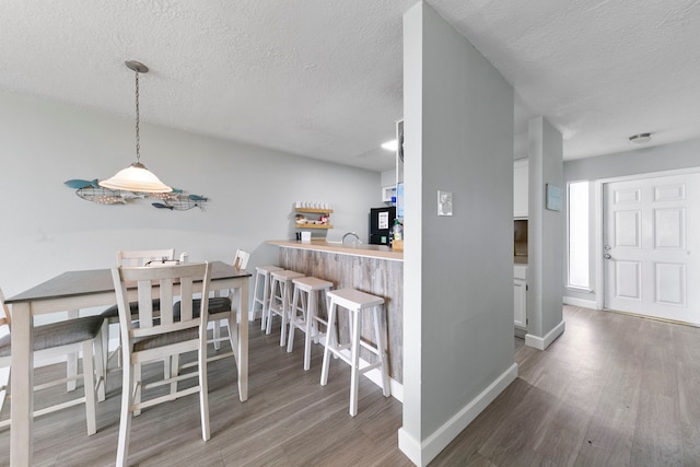 dining room with a textured ceiling and dark wood-type flooring