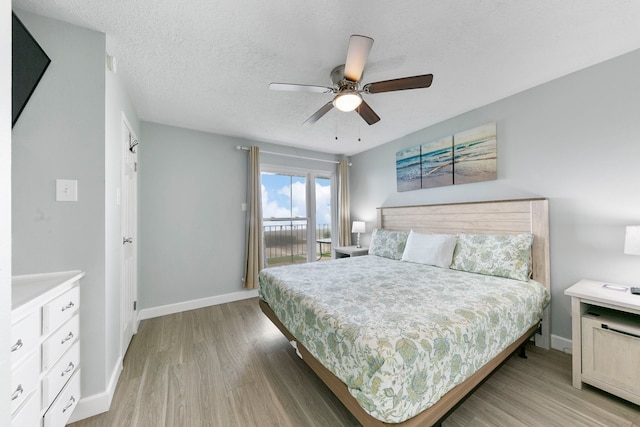 bedroom with a textured ceiling, light hardwood / wood-style floors, and ceiling fan