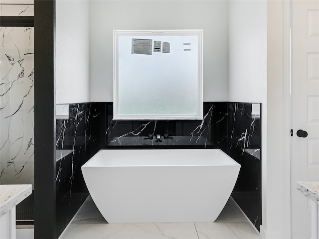 bathroom with vanity, a tub, and tile walls