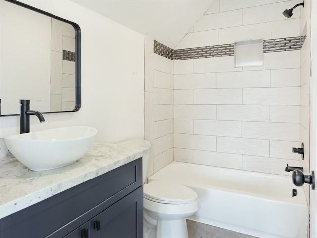 full bathroom featuring vanity, lofted ceiling, tiled shower / bath combo, and toilet