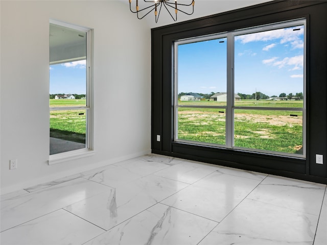 unfurnished room featuring an inviting chandelier and a rural view