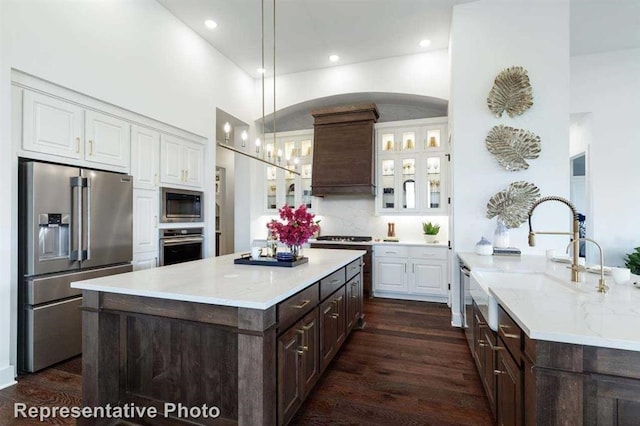 kitchen featuring appliances with stainless steel finishes, white cabinetry, decorative light fixtures, and dark hardwood / wood-style flooring