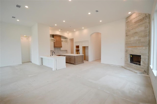 unfurnished living room with sink and a fireplace