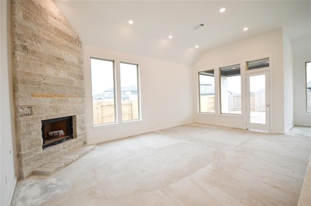 unfurnished living room featuring lofted ceiling and a stone fireplace