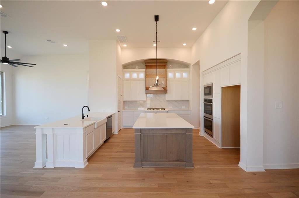 kitchen featuring stainless steel appliances, a kitchen island, visible vents, and white cabinets