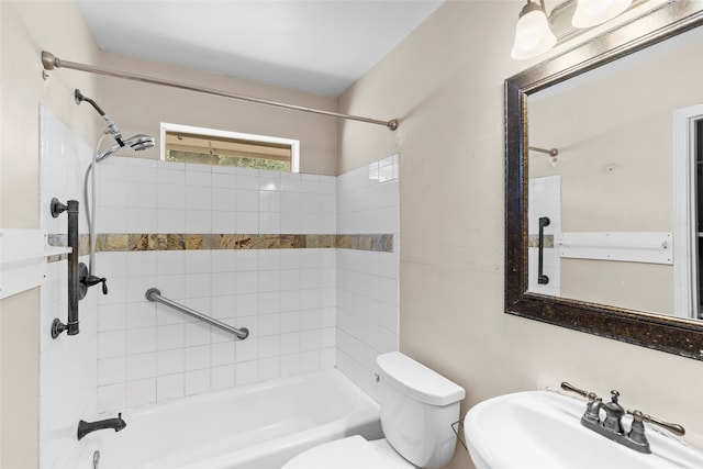 full bathroom featuring sink, tiled shower / bath combo, and toilet