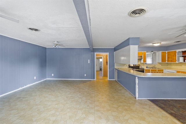 kitchen with beamed ceiling, a textured ceiling, stainless steel range with electric cooktop, and sink