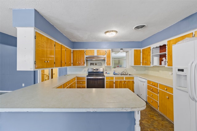 kitchen featuring kitchen peninsula, a textured ceiling, white appliances, and sink