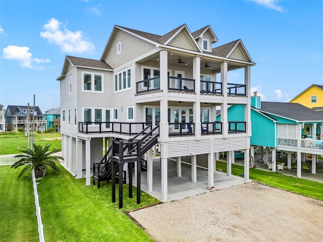 back of property with a balcony, a yard, and a carport