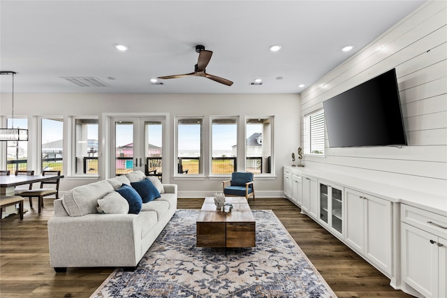 living room with dark wood-type flooring and ceiling fan