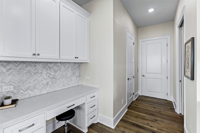 office with dark wood-type flooring and built in desk