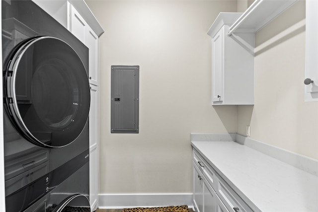 clothes washing area featuring stacked washer and clothes dryer, electric panel, and cabinets