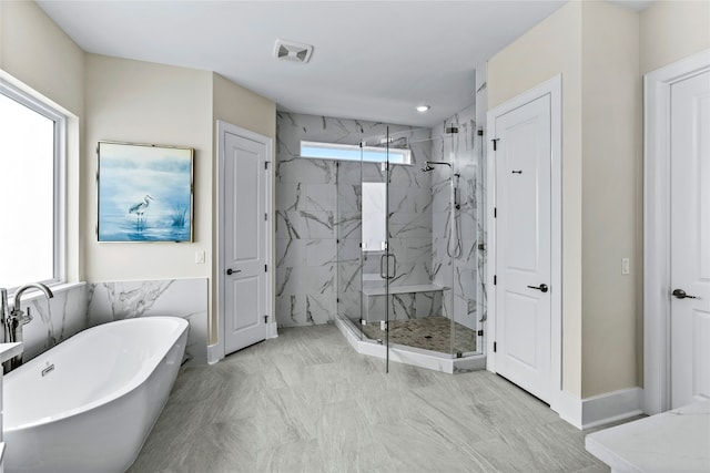 bathroom featuring a wealth of natural light and plus walk in shower