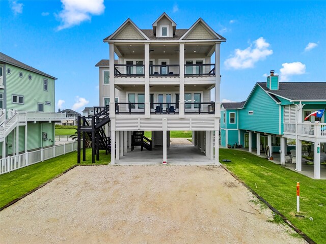 view of front of home featuring a carport, a front lawn, and a balcony