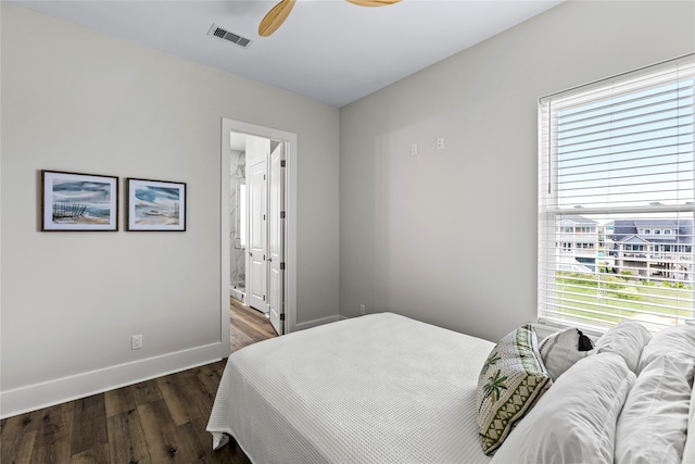 bedroom with ensuite bath, ceiling fan, and dark hardwood / wood-style flooring