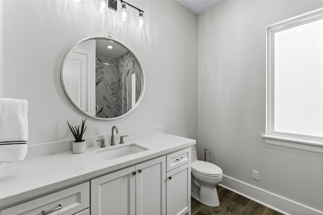 bathroom with hardwood / wood-style floors, vanity, toilet, and a shower