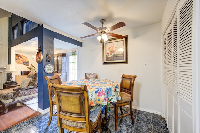 tiled dining room featuring a textured ceiling and ceiling fan