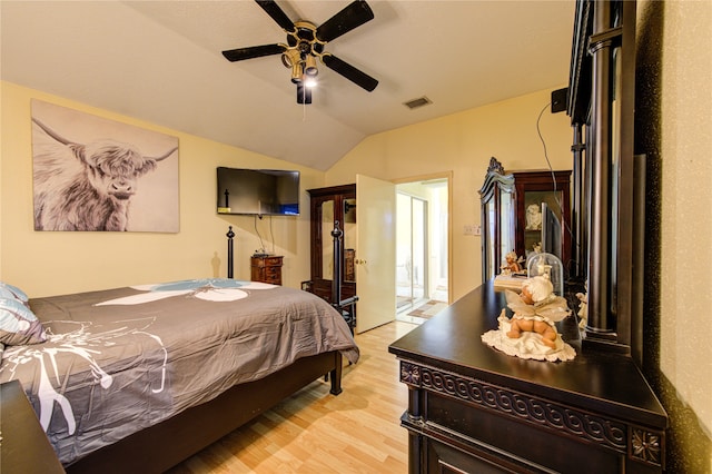 bedroom featuring light hardwood / wood-style flooring, vaulted ceiling, and ceiling fan