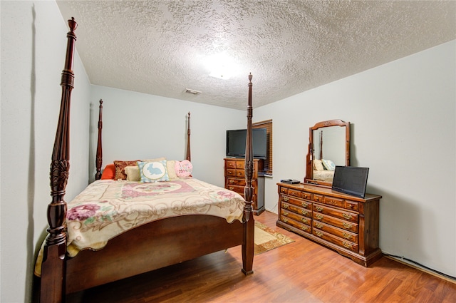 bedroom featuring a textured ceiling and wood-type flooring