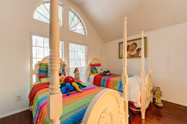 bedroom with a textured ceiling, vaulted ceiling, and dark hardwood / wood-style floors