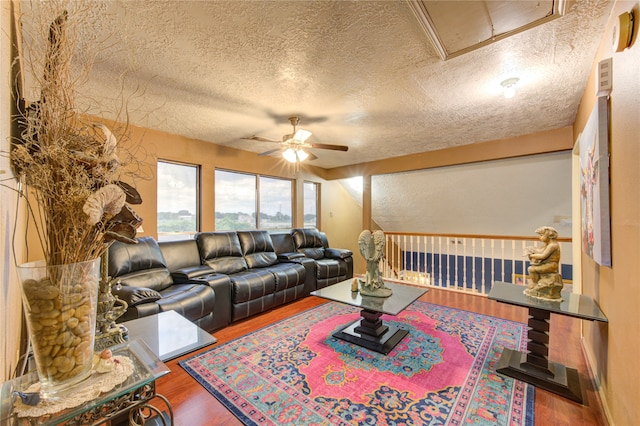 living room with a textured ceiling, hardwood / wood-style flooring, and ceiling fan