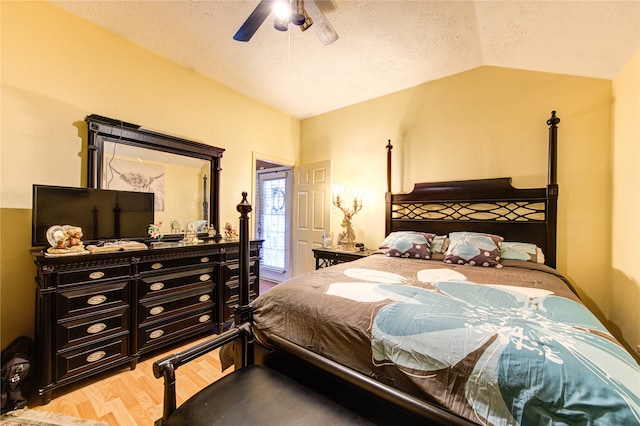 bedroom featuring lofted ceiling, a textured ceiling, wood-type flooring, and ceiling fan