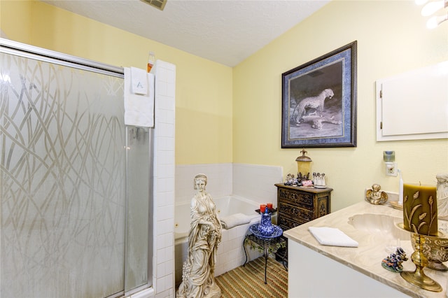 bathroom with vanity, independent shower and bath, and a textured ceiling