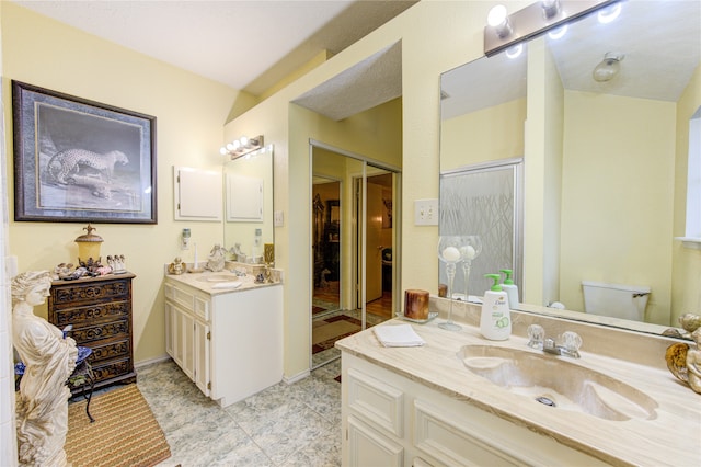 bathroom featuring toilet, vanity, and tile patterned flooring