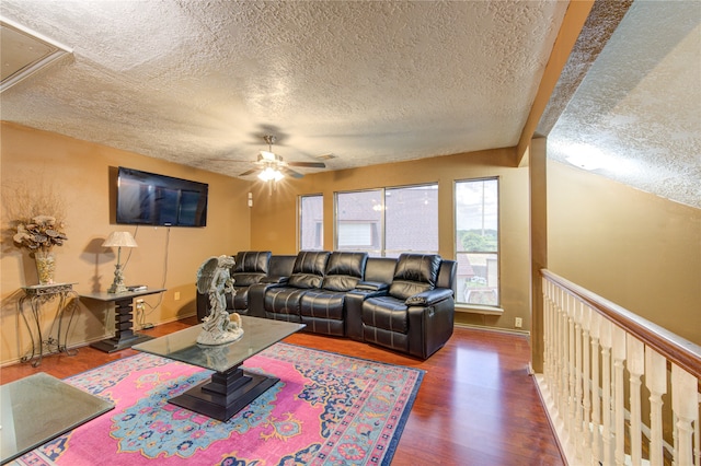 living room with a textured ceiling, beam ceiling, ceiling fan, and dark hardwood / wood-style flooring